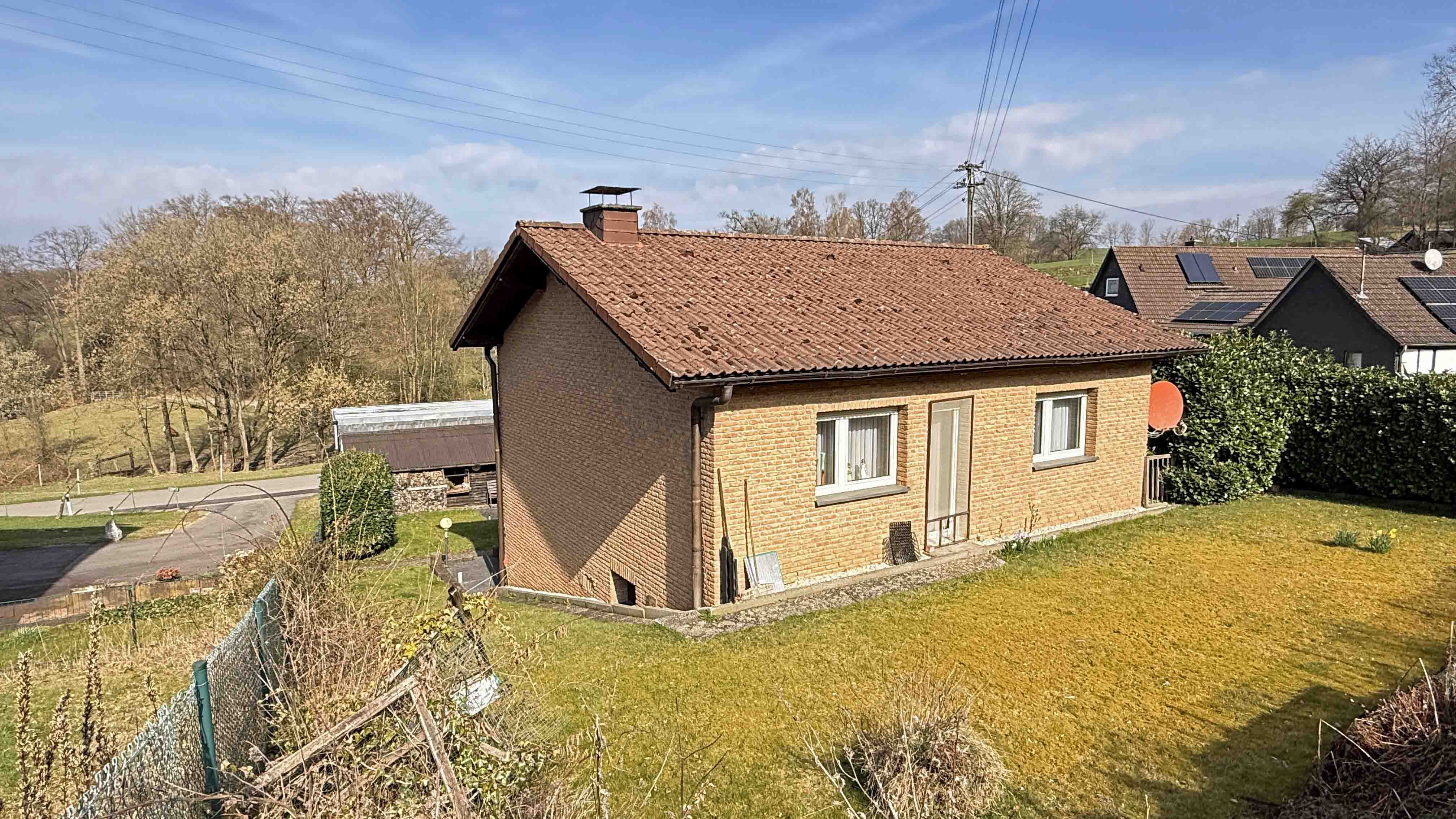Reichshof-Buchen: Mit Wohnmobil-Carport und 642 m² eingezäuntem Grundstück, Hausrück-/ Südseite mit Tür zur ebener Rasenfläche